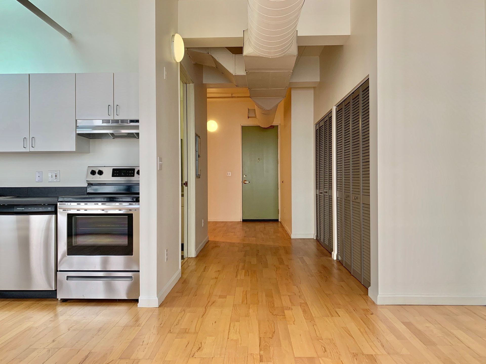 A kitchen with stainless steel appliances and hardwood floors