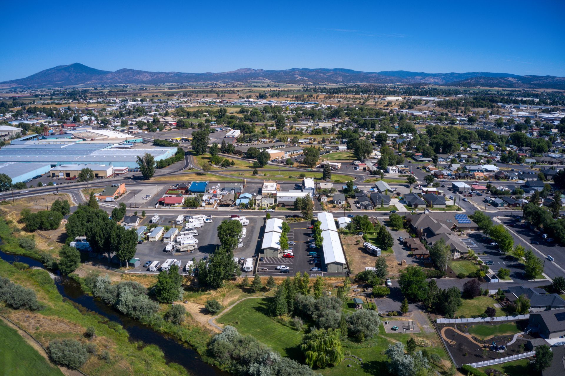 An aerial view of a small town with mountains in the background.