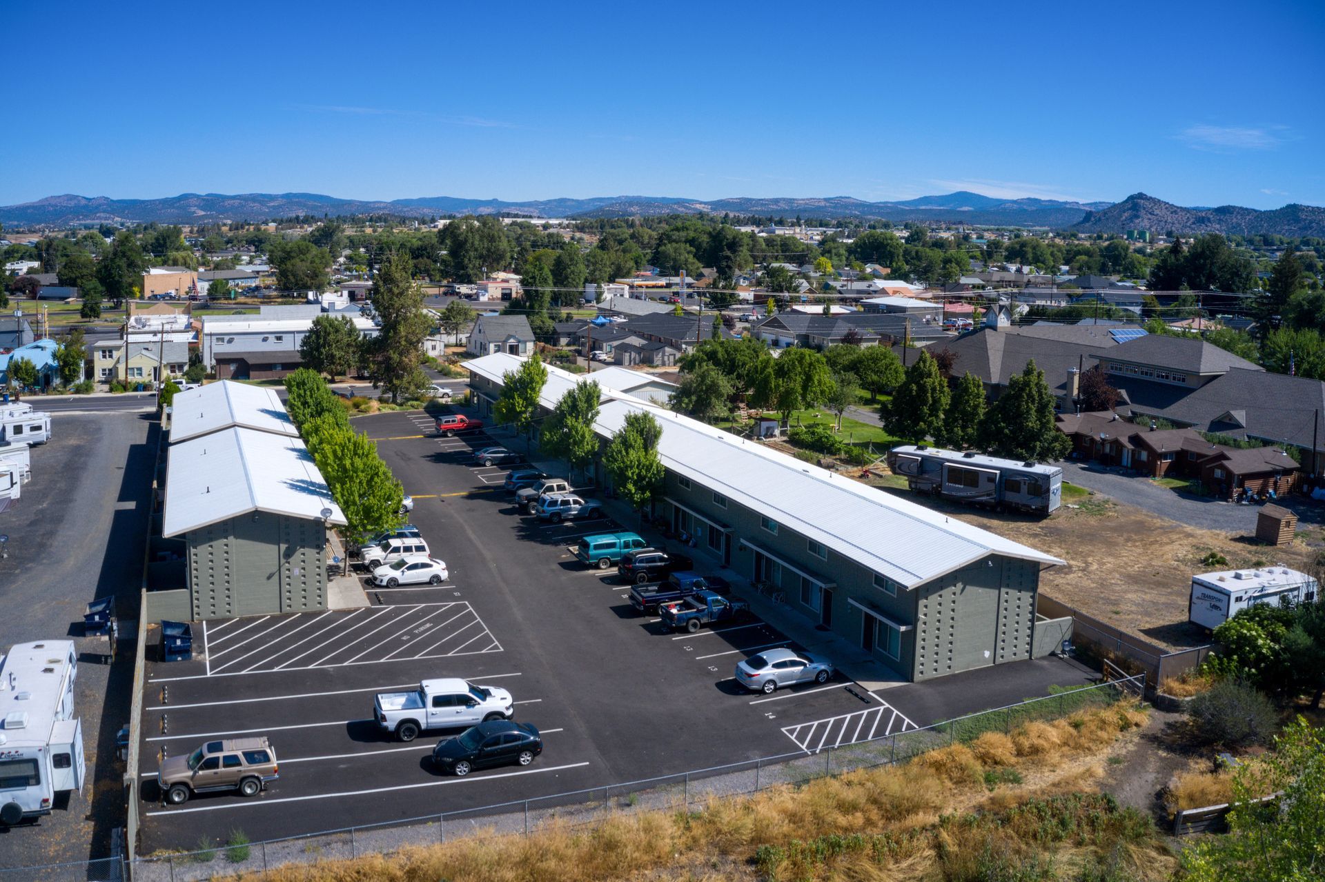 An aerial view of a parking lot with a building in the background