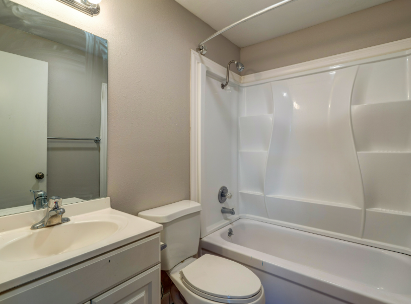A bathroom with a toilet , sink and bathtub.