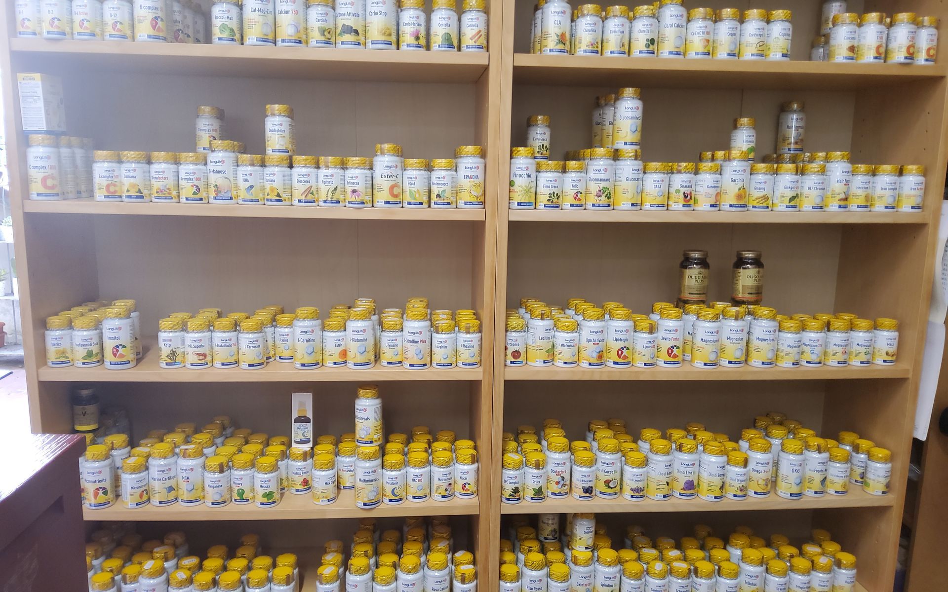 Uno scaffale pieno di bottiglie e barattoli di medicine.