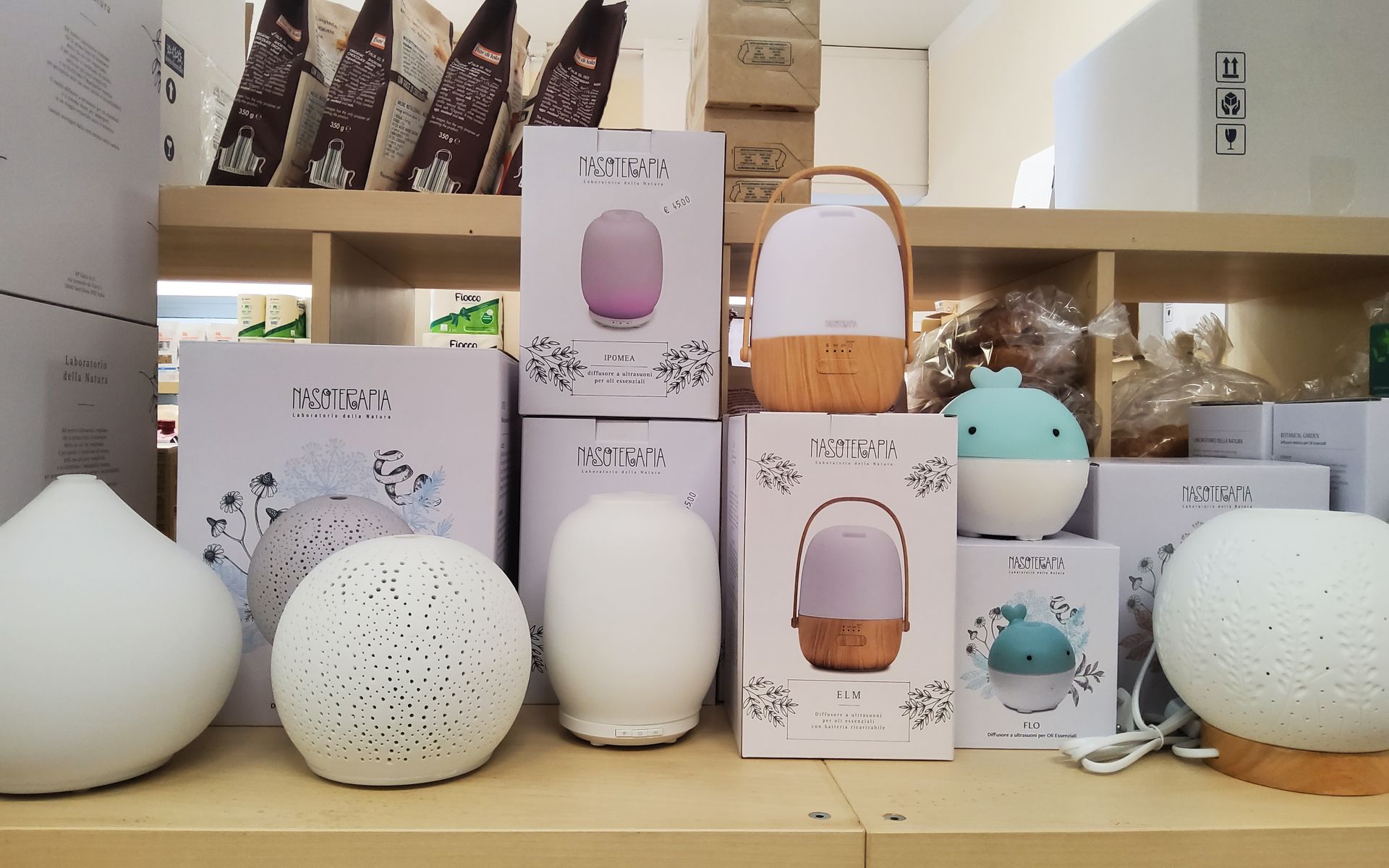 Uno scaffale pieno di lampade e scatole di vario tipo.