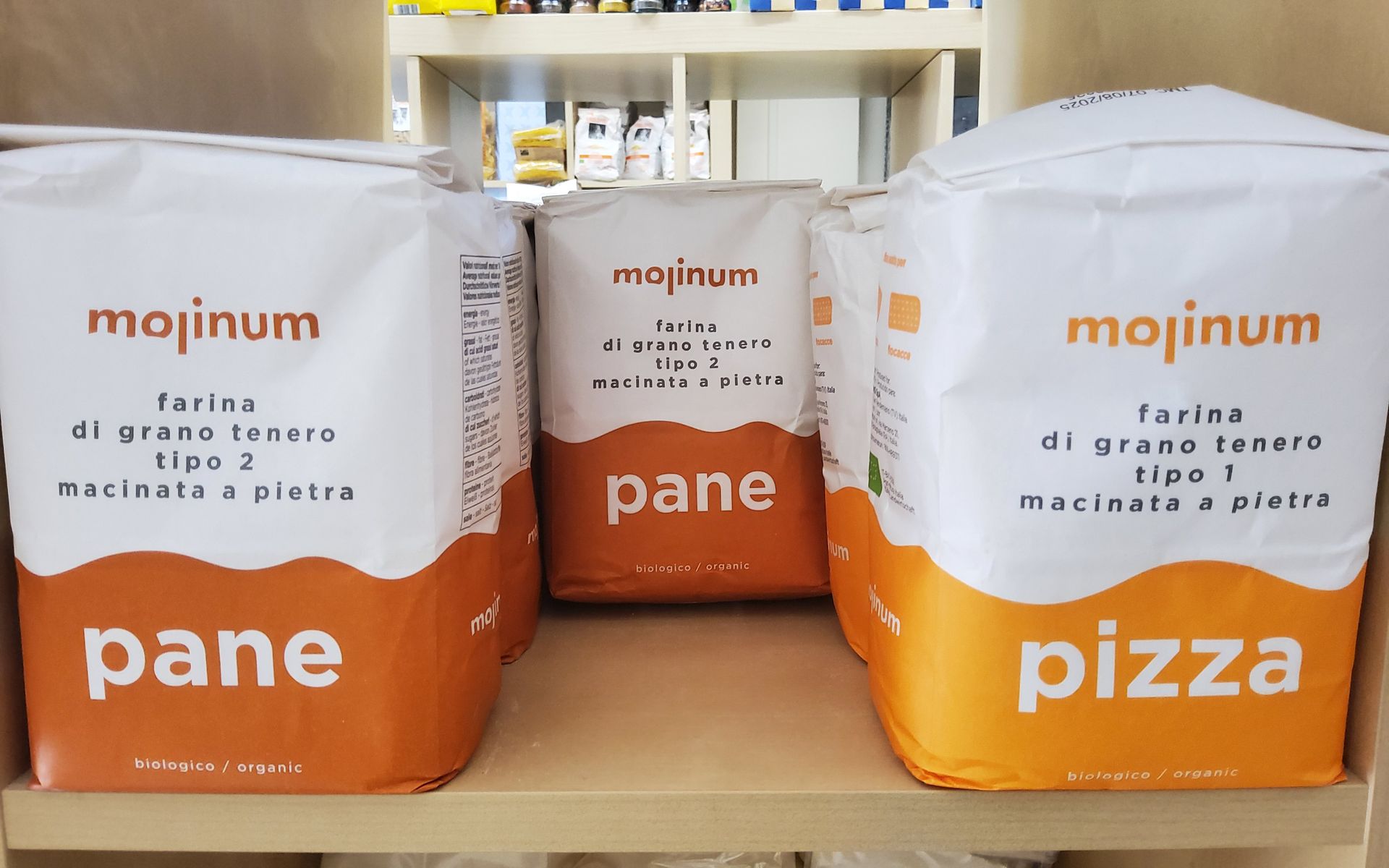 Tre sacchetti di pane e pizza sono su uno scaffale