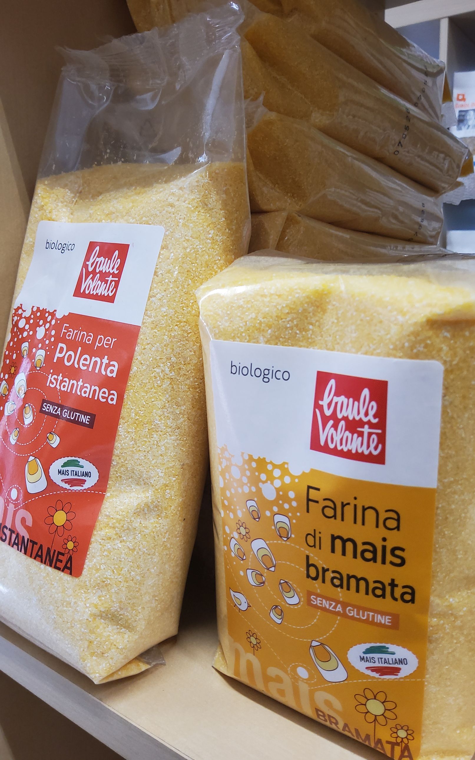 Due sacchi di farina di mais sono appoggiati su uno scaffale.