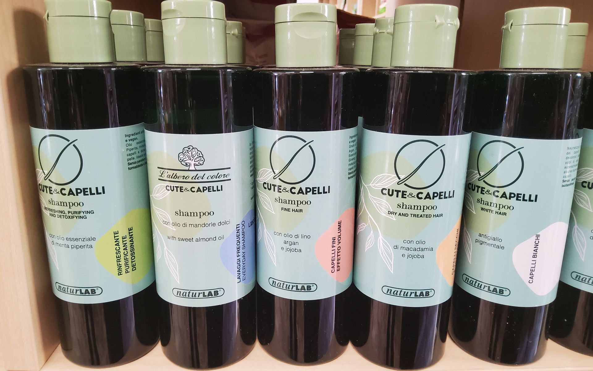 Diverse bottiglie di shampoo sono allineate su uno scaffale