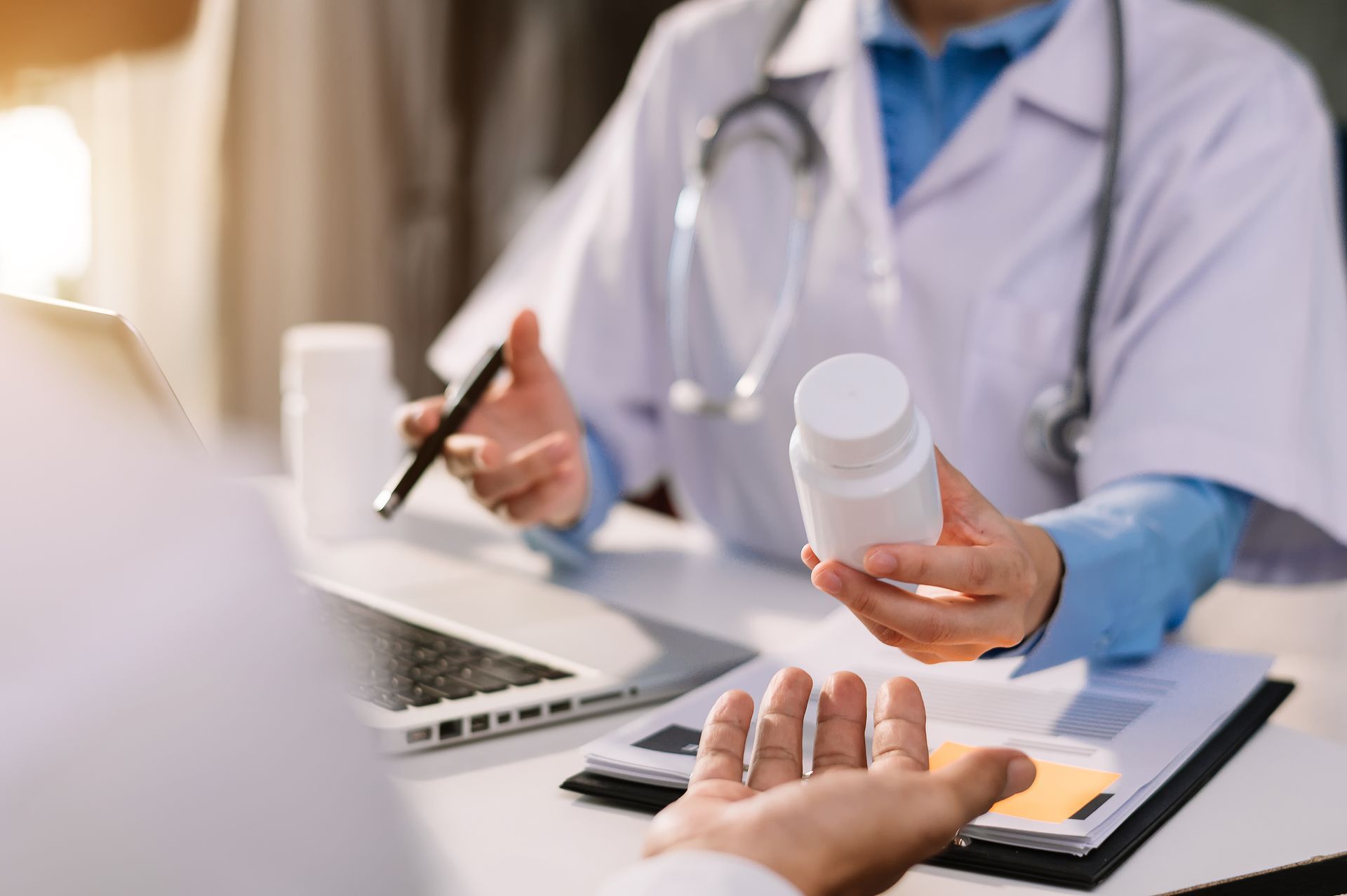 A group of people are sitting around a table with laptops.