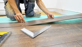 Man Installing floor — insurance adjusters in Albany, NY