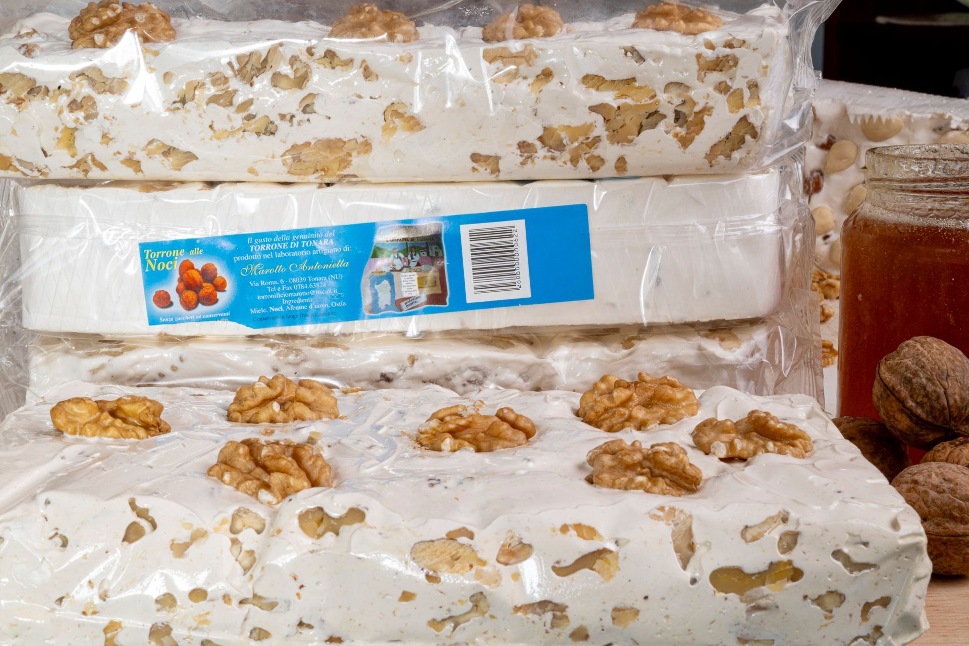 Scaffali di un negozio pieni di prodotti confezionati, ceramiche e barattoli decorati per Natale.