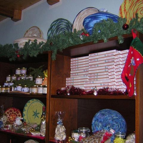 Scaffali di un negozio pieni di prodotti confezionati, ceramiche e barattoli decorati per Natale.