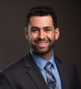 A man in a suit and tie is smiling for the camera.