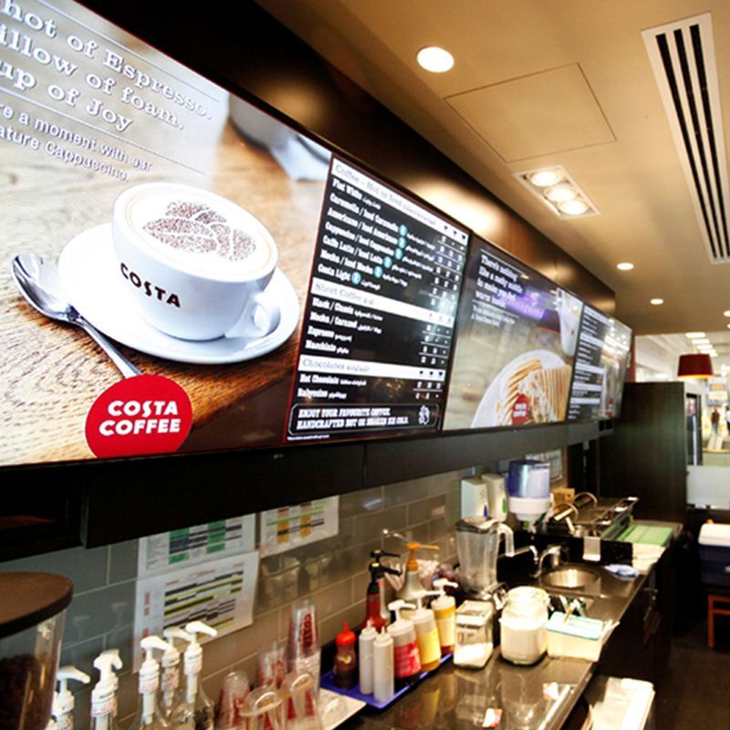 A costa coffee sign hangs above a counter in a restaurant