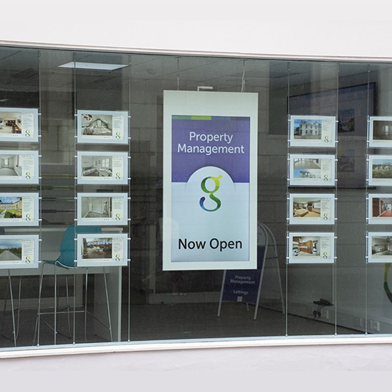 A property management sign hangs in a window