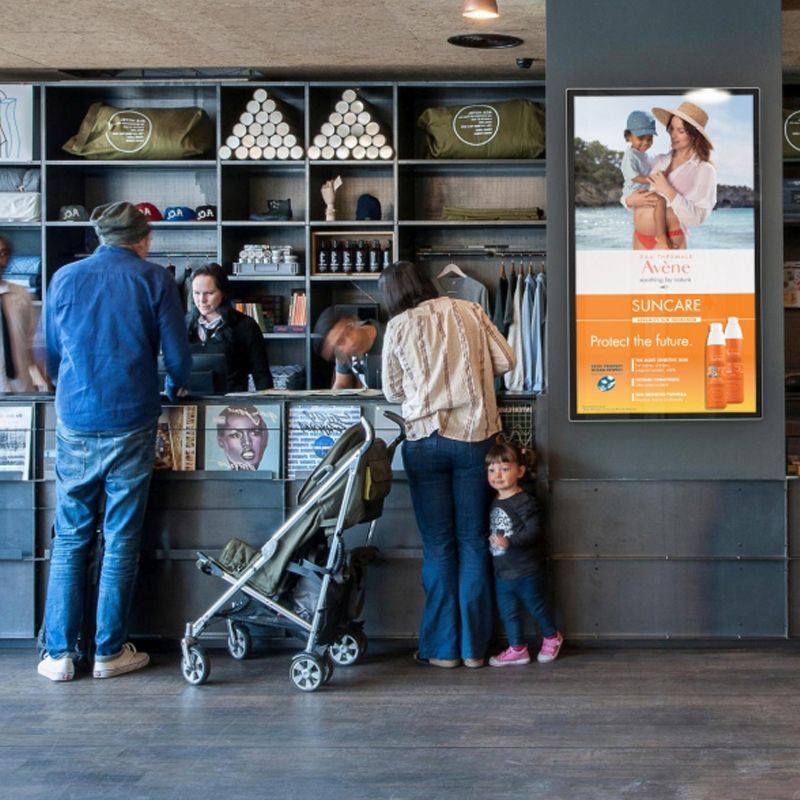 A group of people are standing in front of a counter in a store.