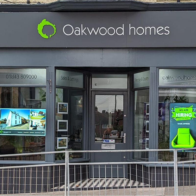 The front of a oakwood homes store with a fence around it