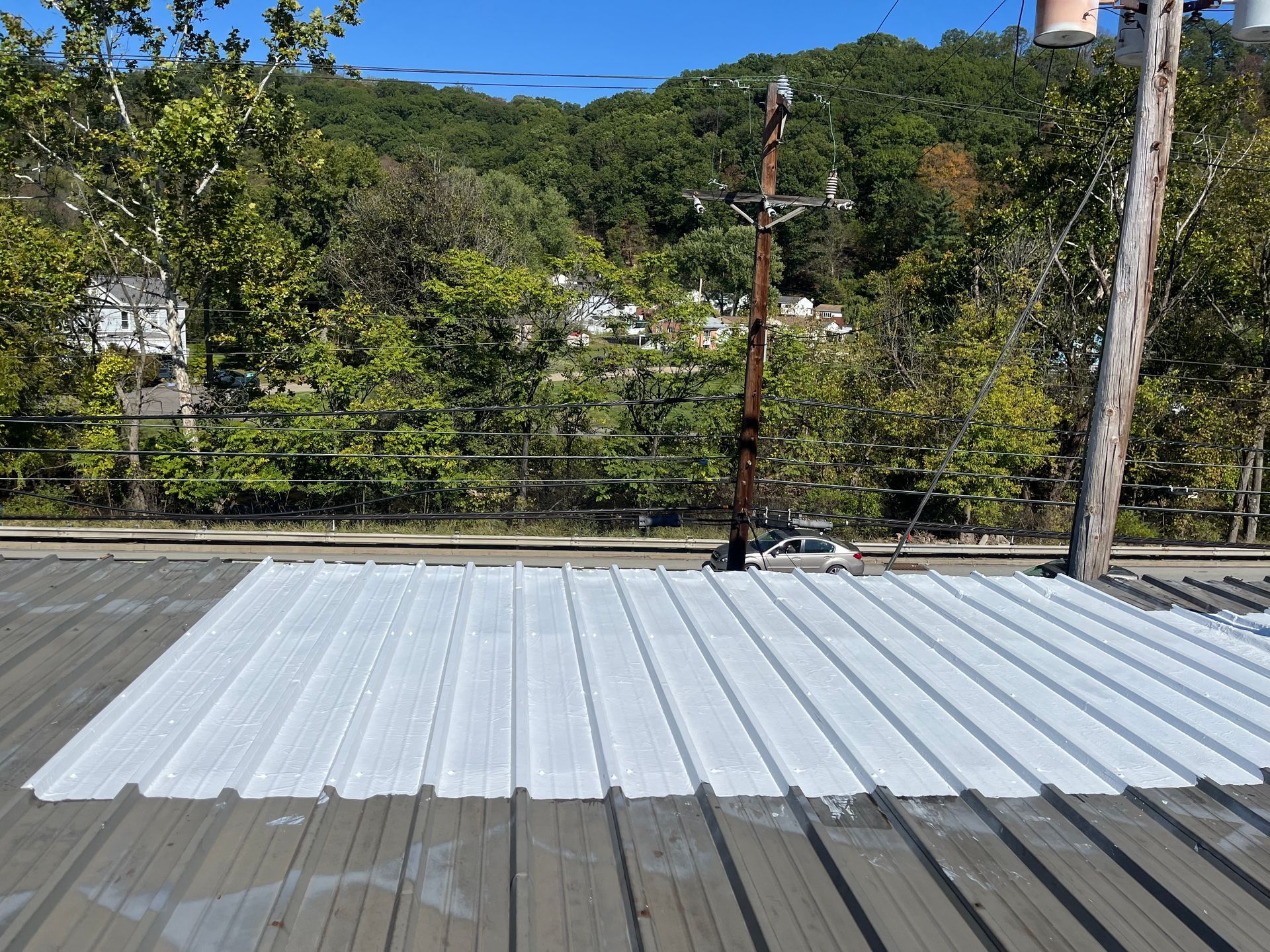 A man is standing on top of a white roof.