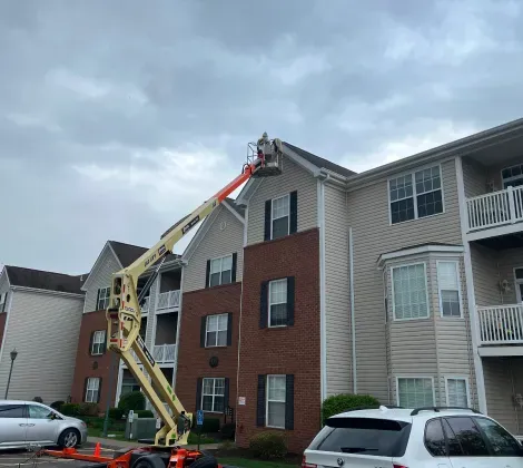A crane is being used to clean the roof of a building.