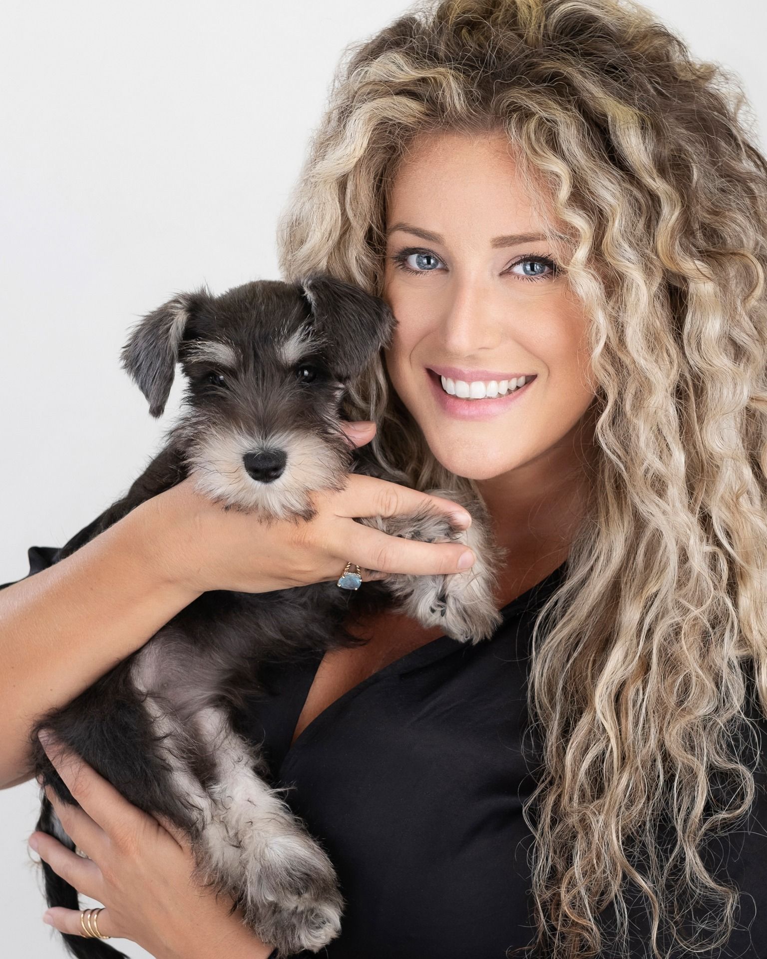 Person holding a small schnauzer puppy