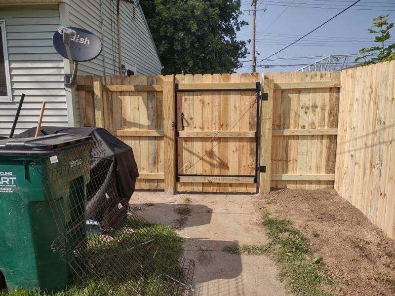 Wooden fence with a gate in a backyard.