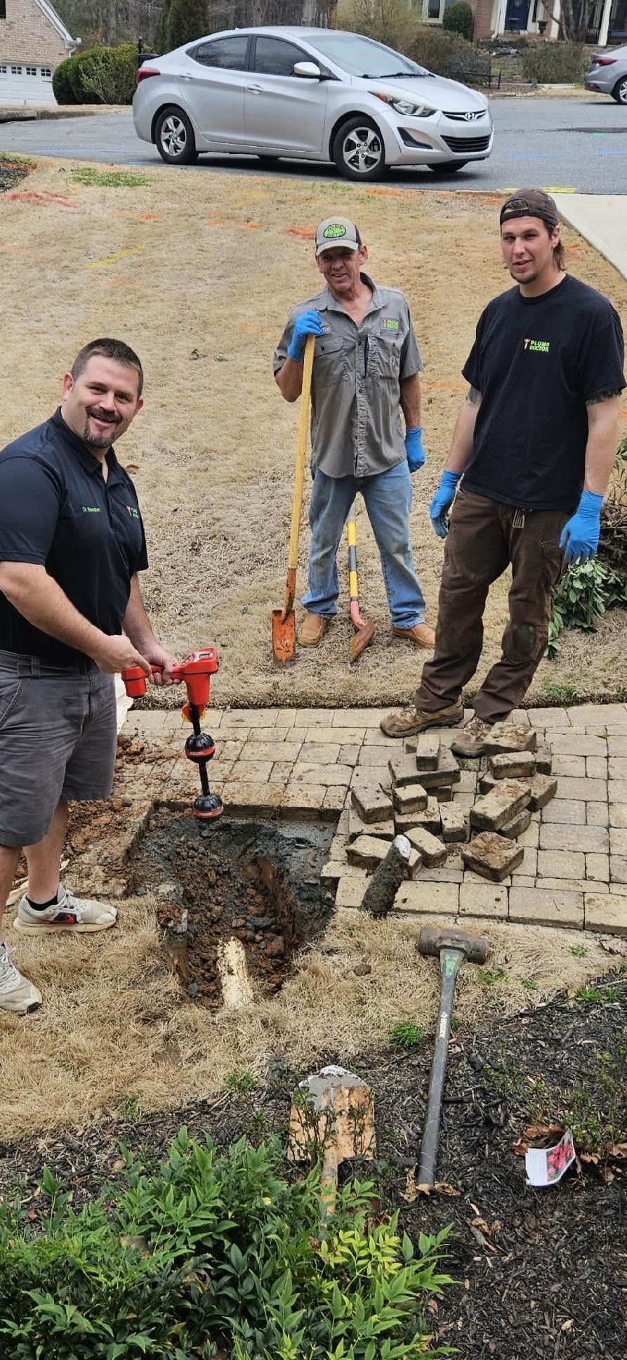 A group of men are digging a hole in the ground.