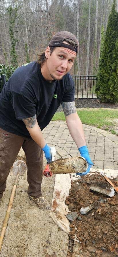 A man is digging in the dirt with a shovel.