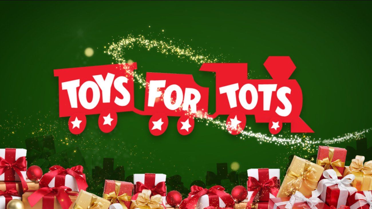 A train with the words `` toys for tots '' on it is surrounded by gifts.