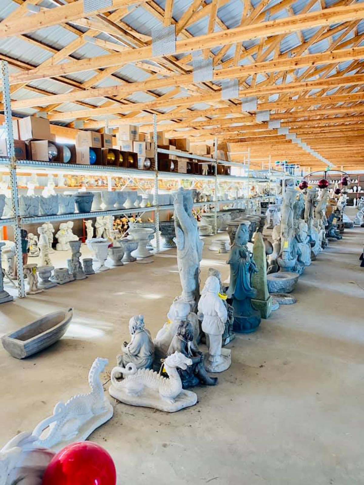 A large warehouse filled with lots of statues and pots.