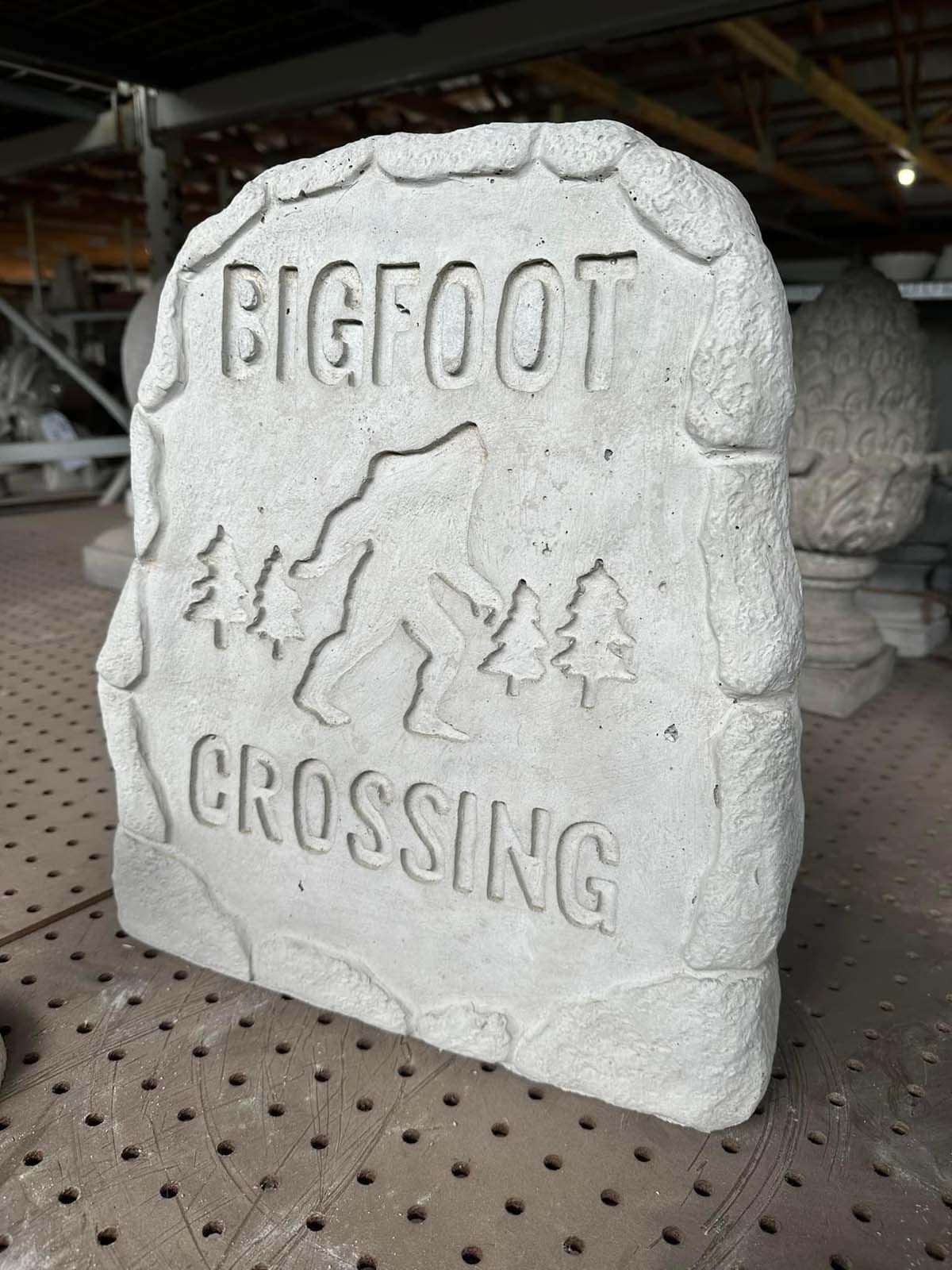 A large white stone with bigfoot crossing written on it