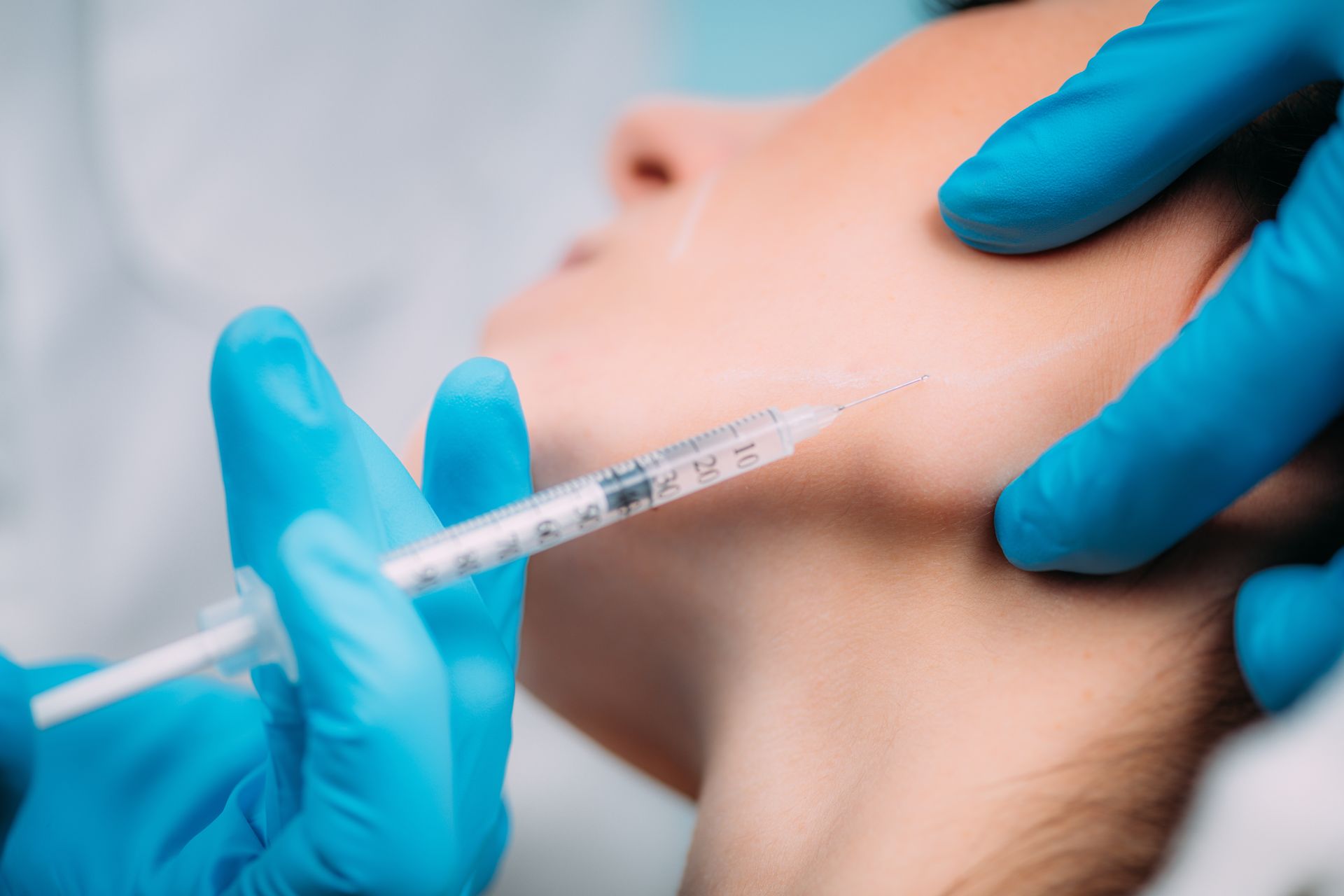 A woman is getting a botox injection in her face.