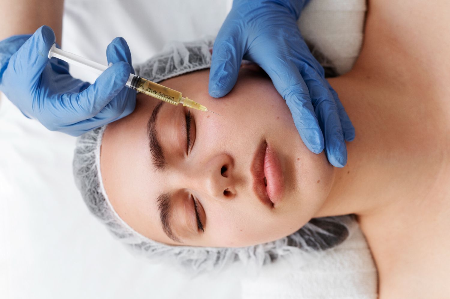 A woman is getting an injection in her face at a beauty salon.