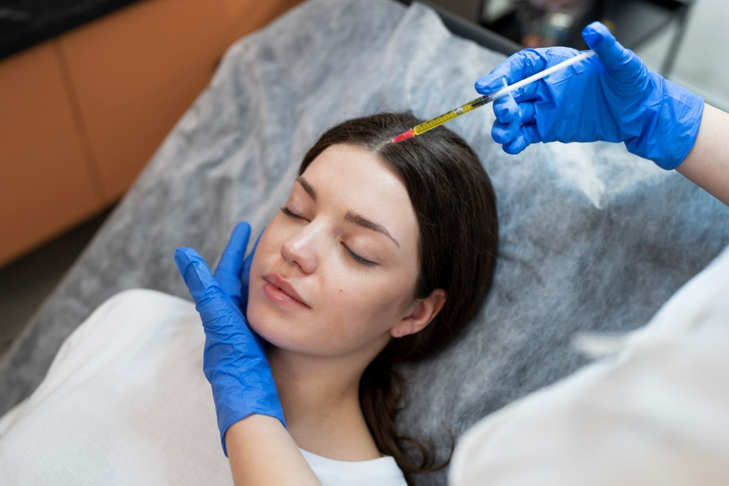 A woman is getting a botox injection in her head.