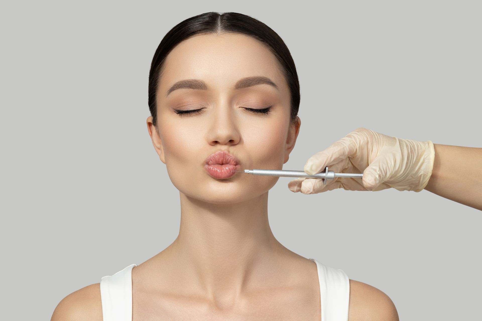A woman is getting a botox injection in her lip.