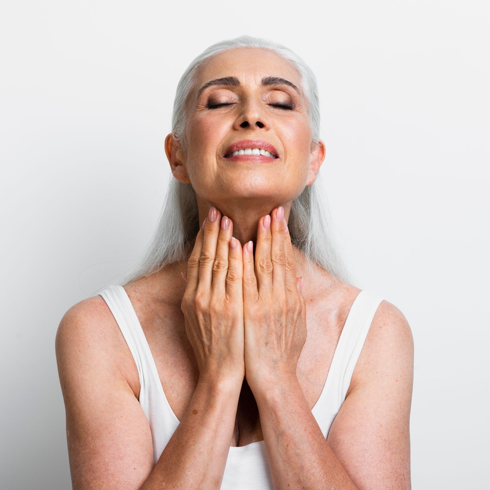 a woman with her eyes closed and her hands on her neck