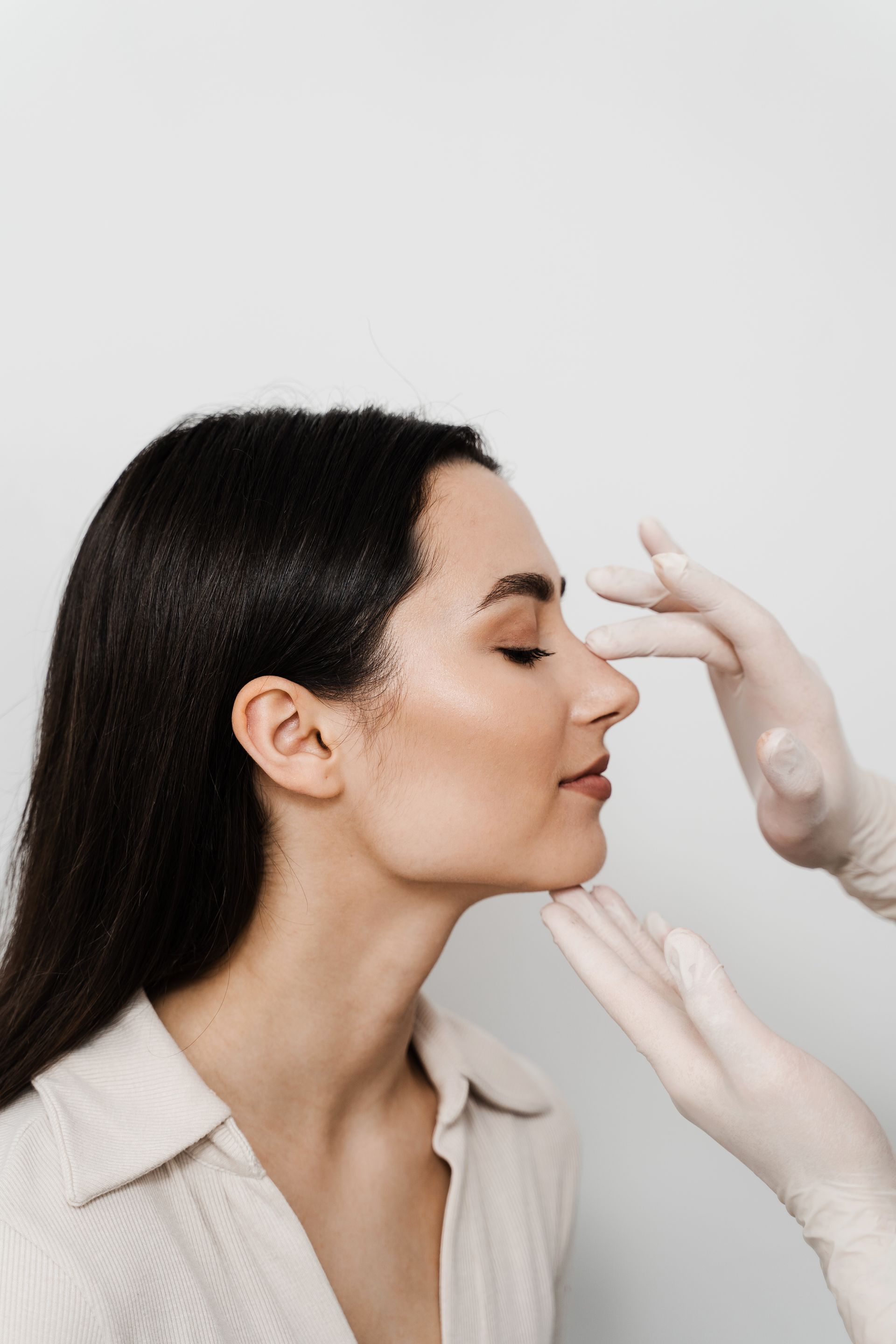 a woman is getting her nose examined by a doctor