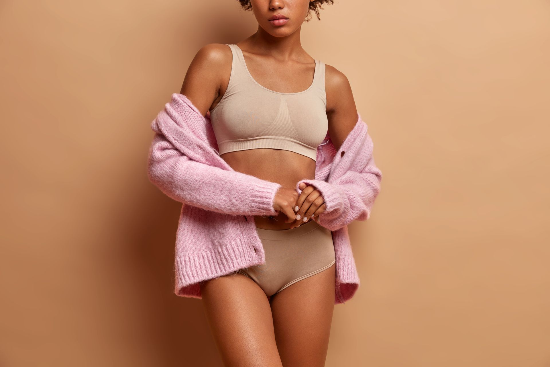 a woman in underwear and a pink sweater