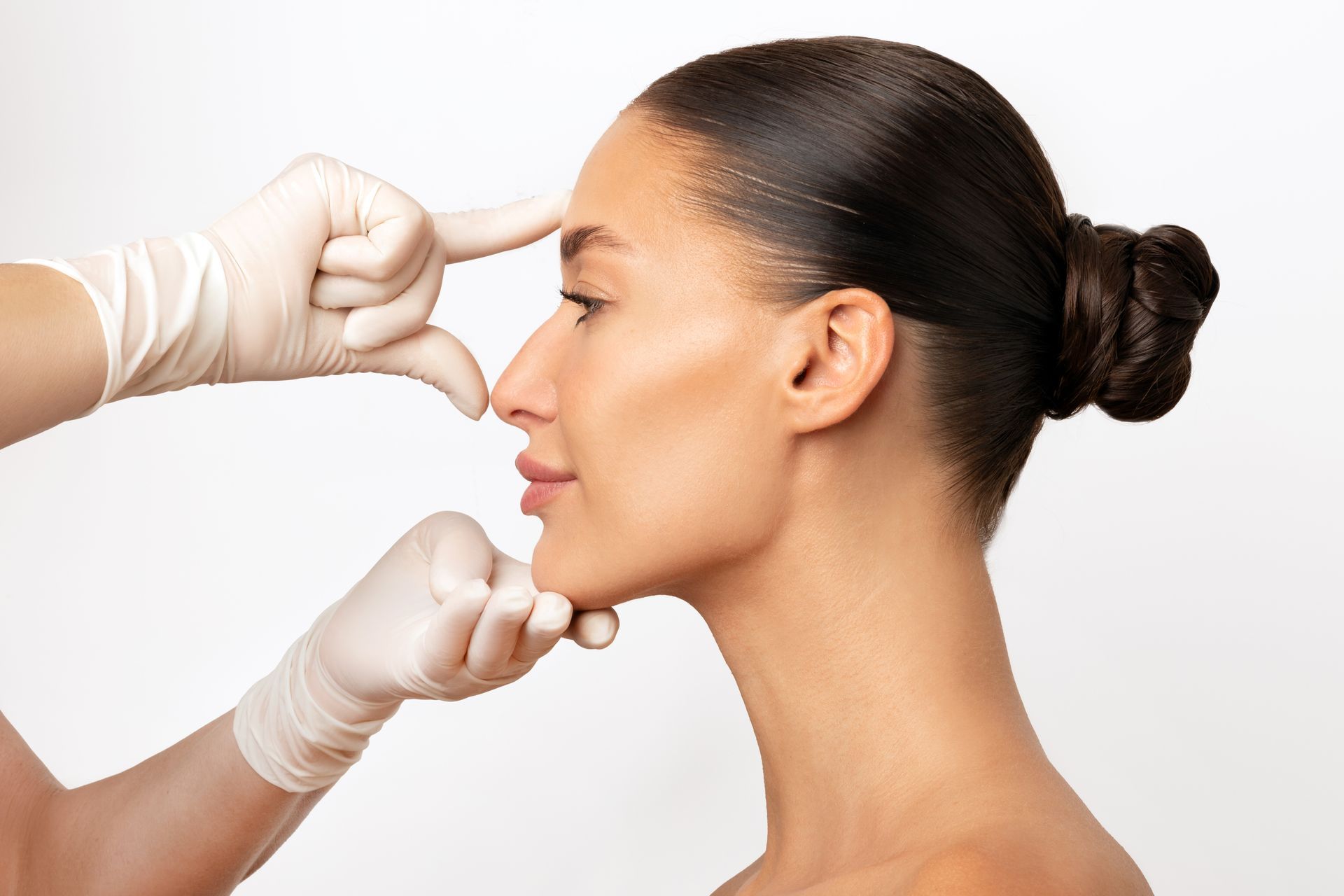 A woman is getting her nose examined by a doctor.