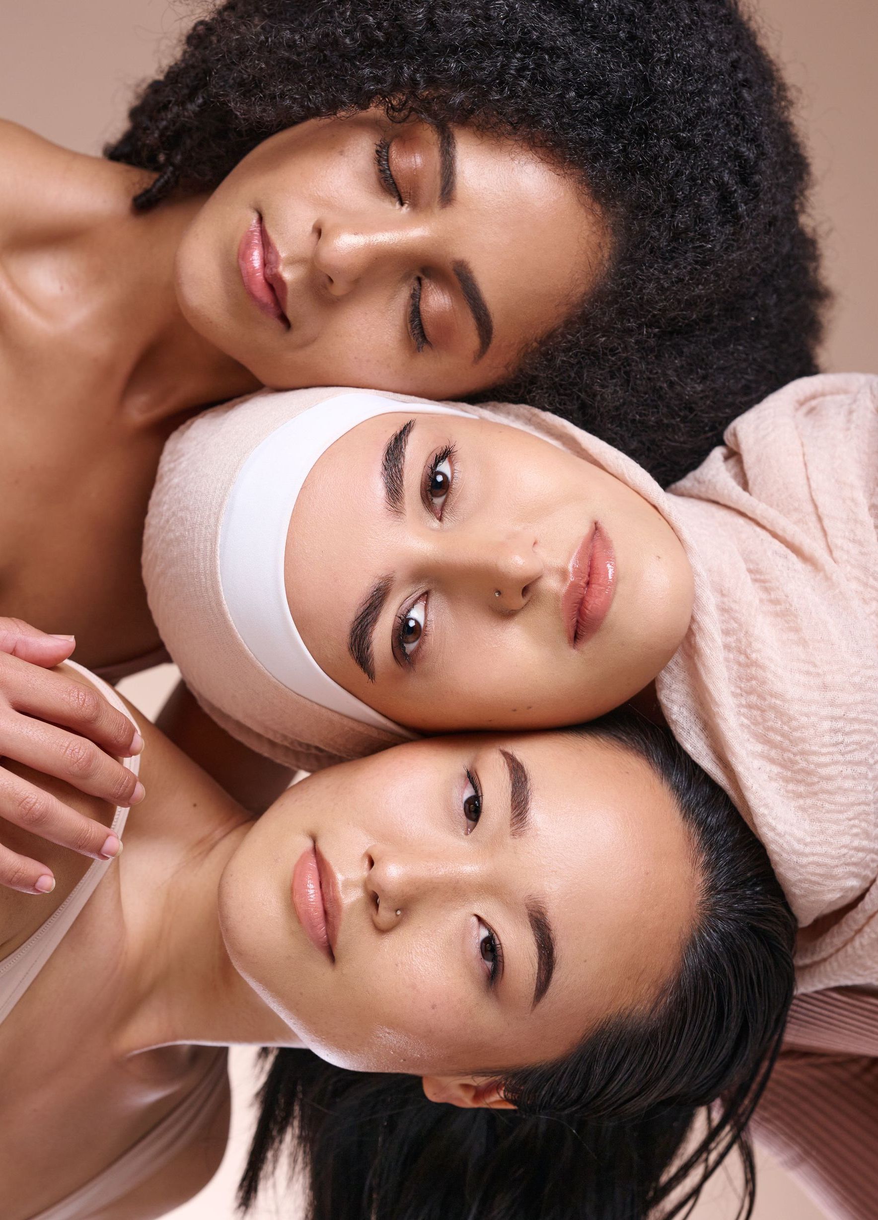 three women laying on top of each other with their eyes closed