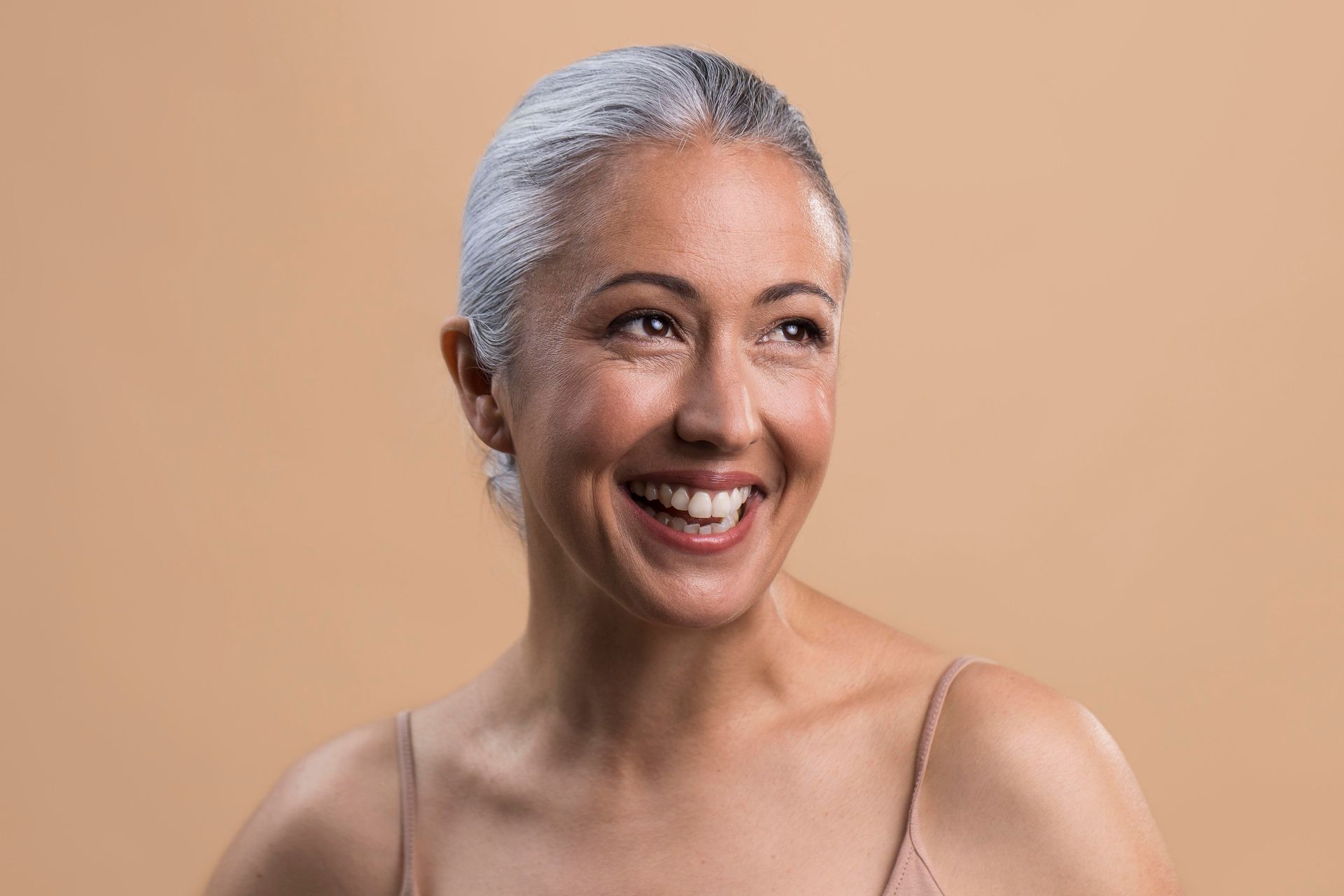 a woman with gray hair is smiling and looking to the side