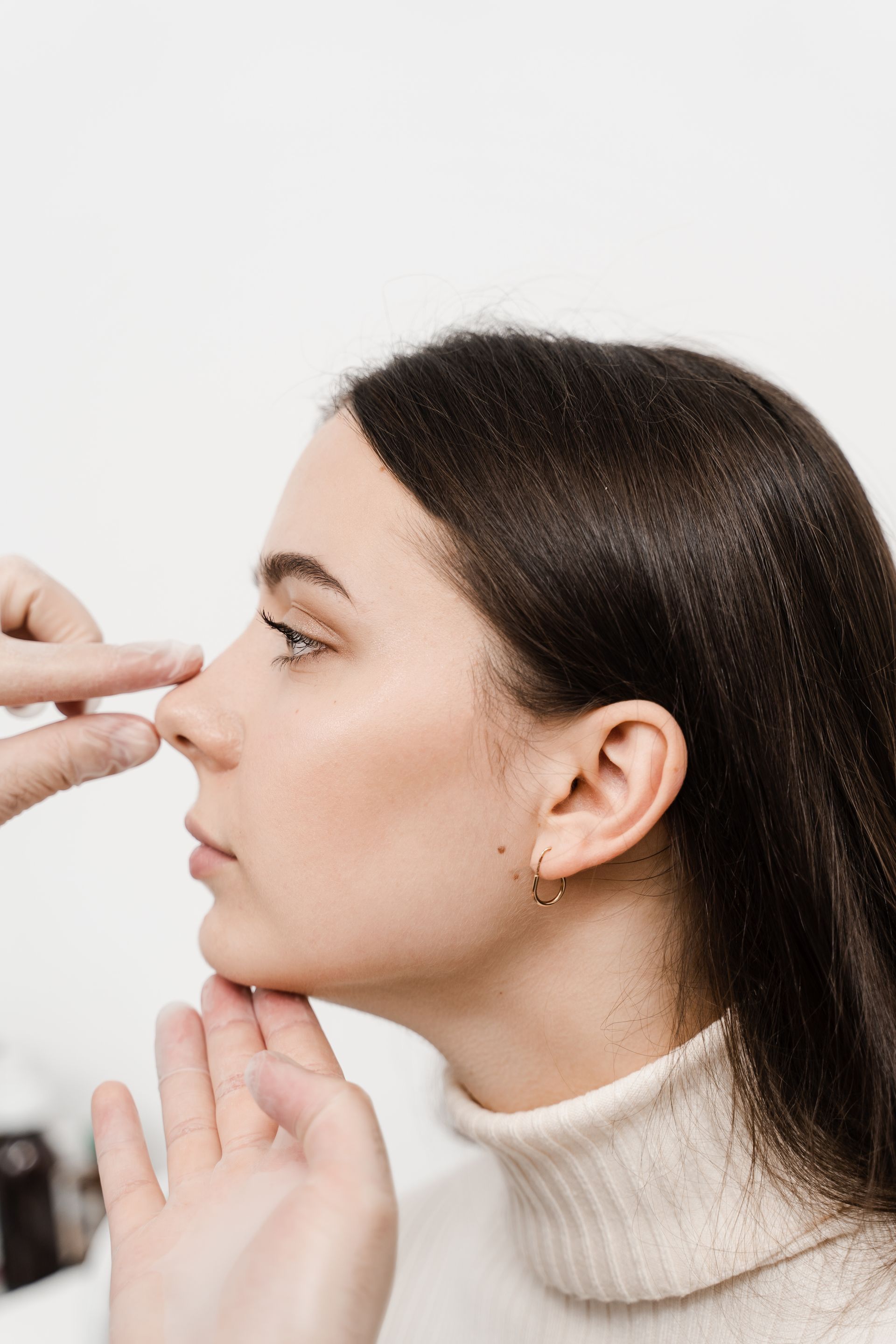a woman is getting her nose examined by a doctor