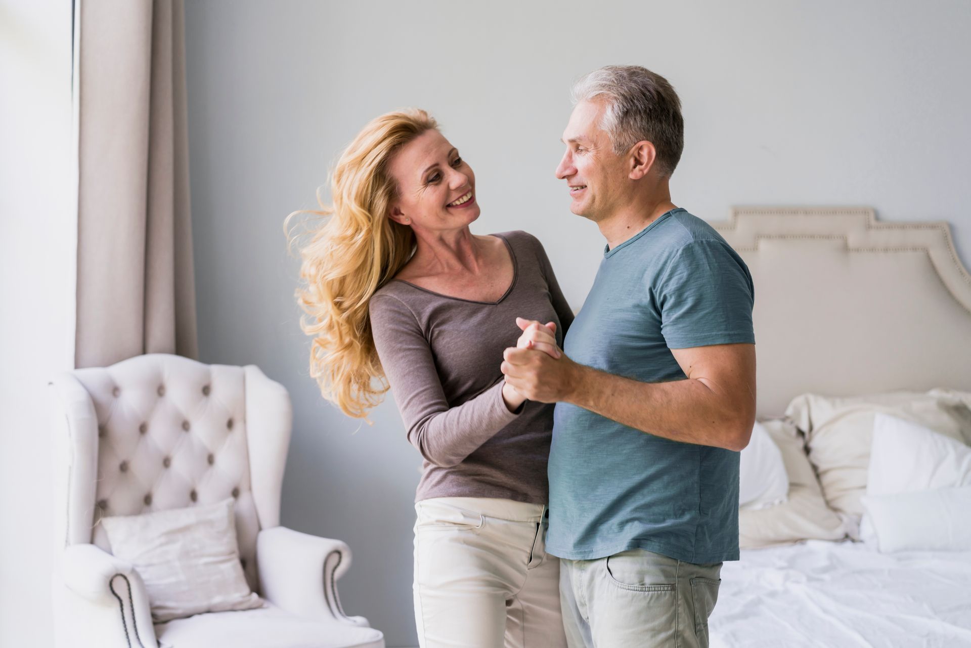 a man and woman are dancing together in a bedroom