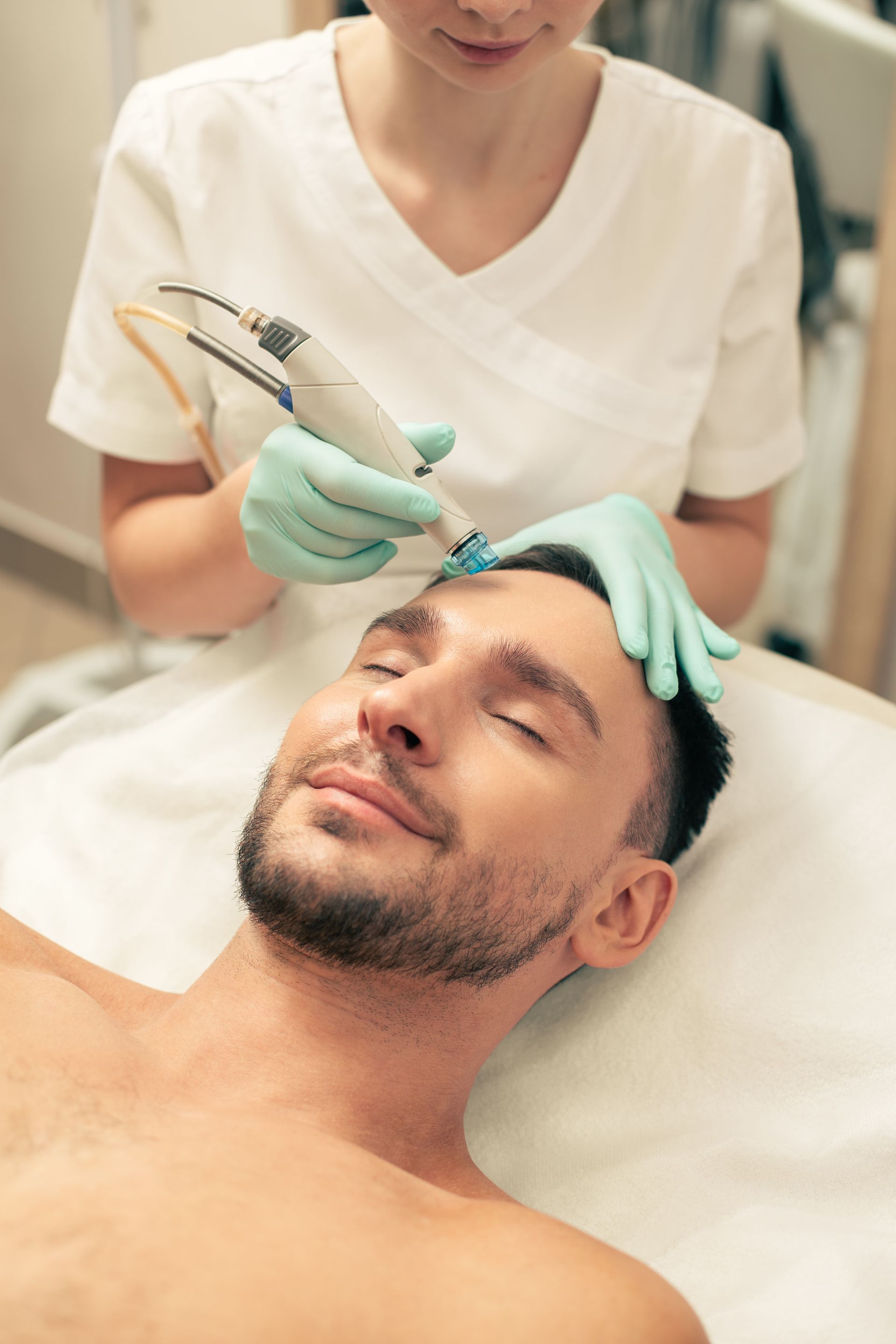 a man with his eyes closed is getting a treatment on his face