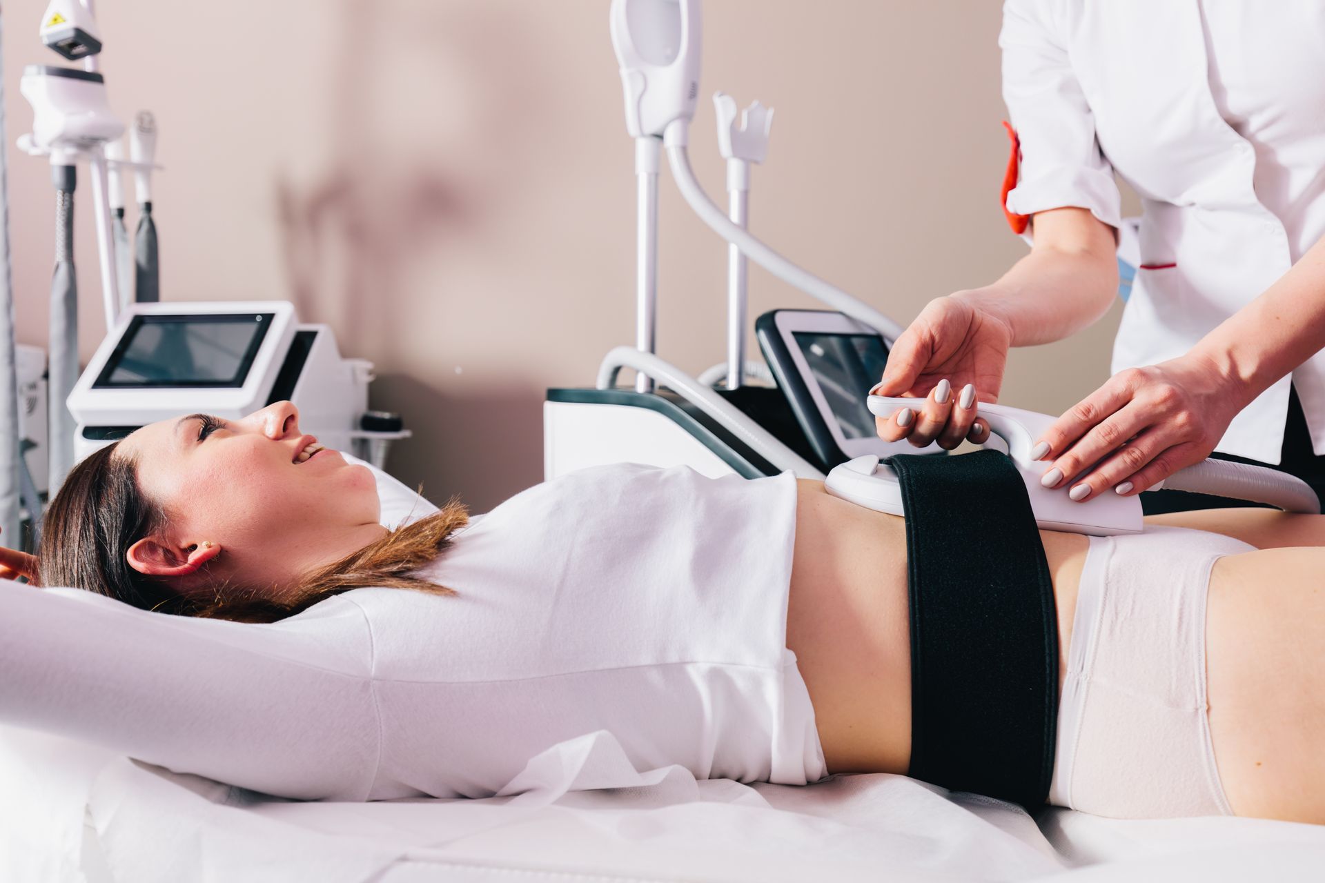 a woman is laying on a bed getting a treatment on her stomach