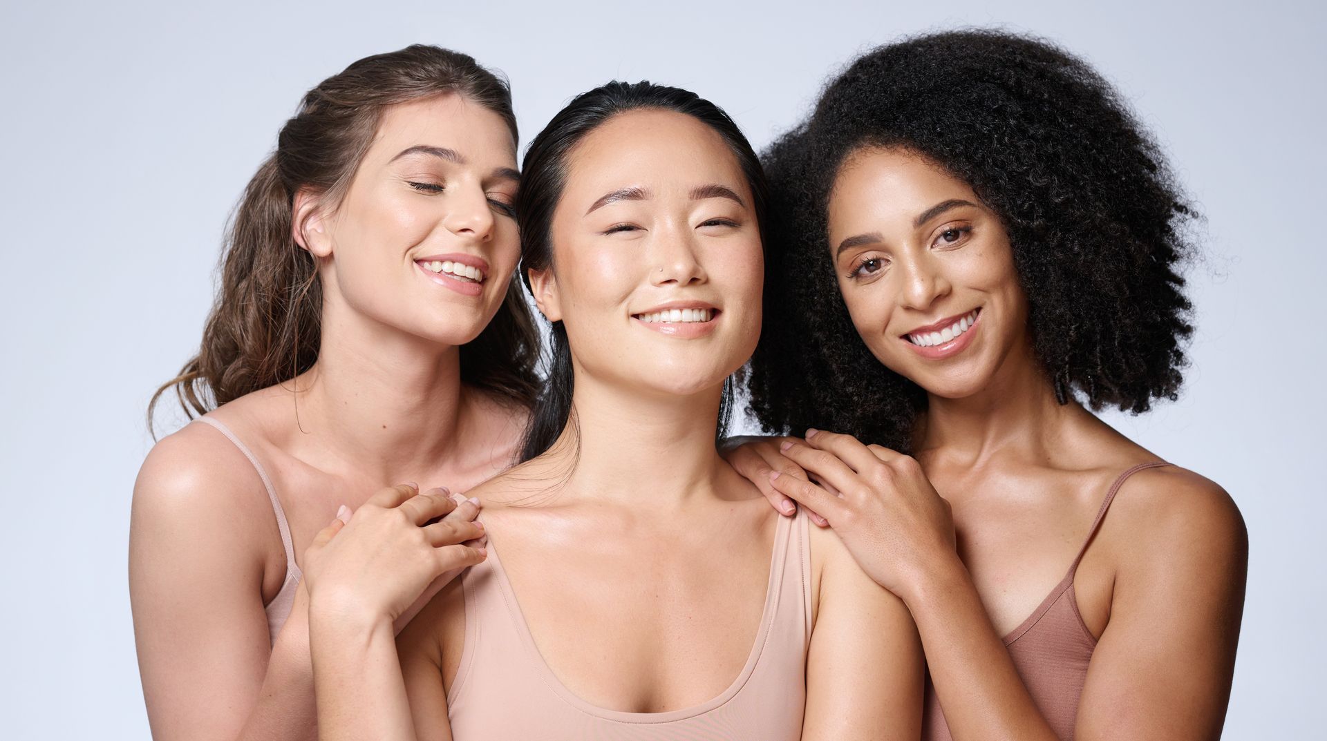 three women are posing for a picture and one has her eyes closed
