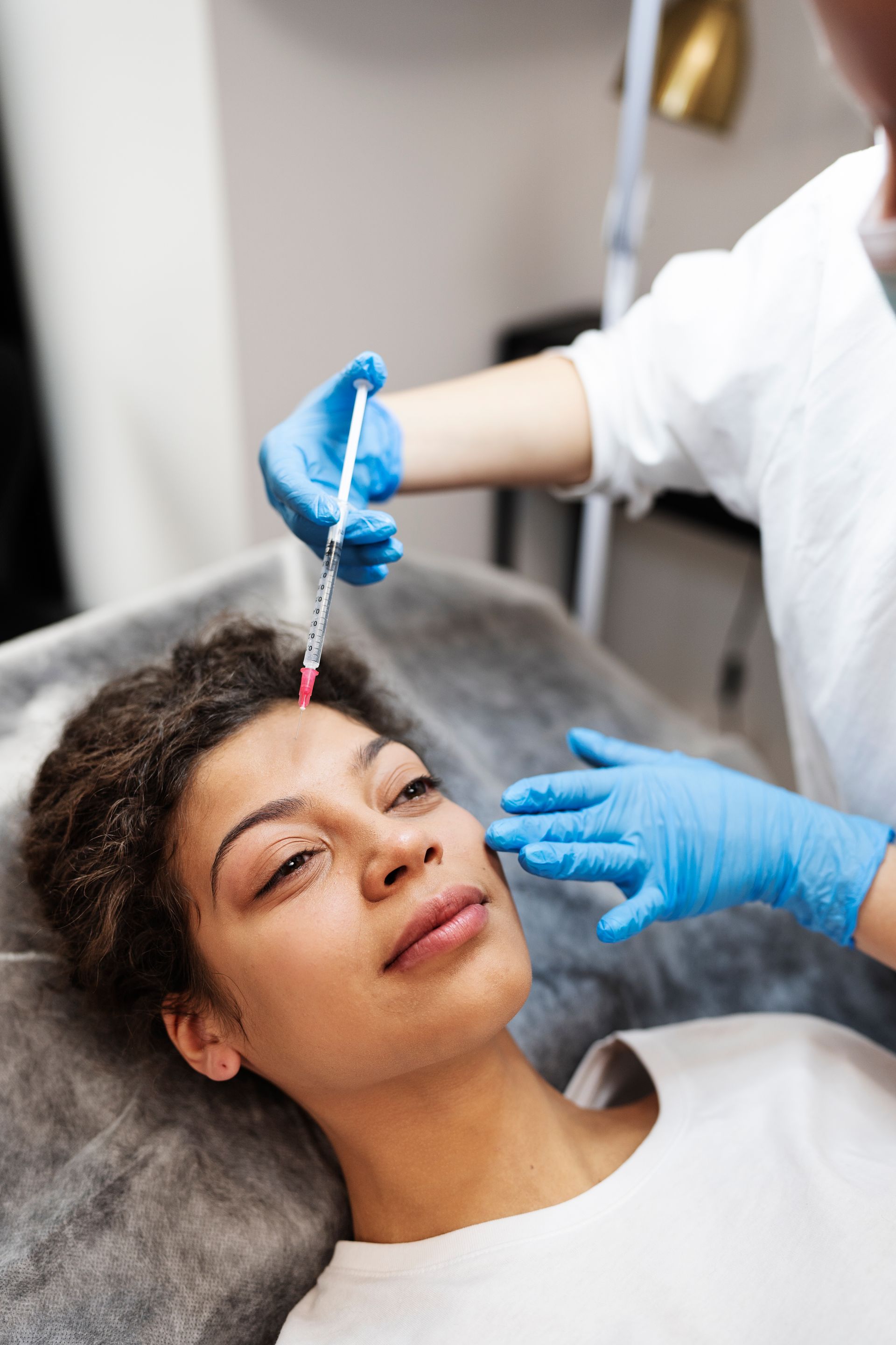 a woman is getting a botox injection on her forehead