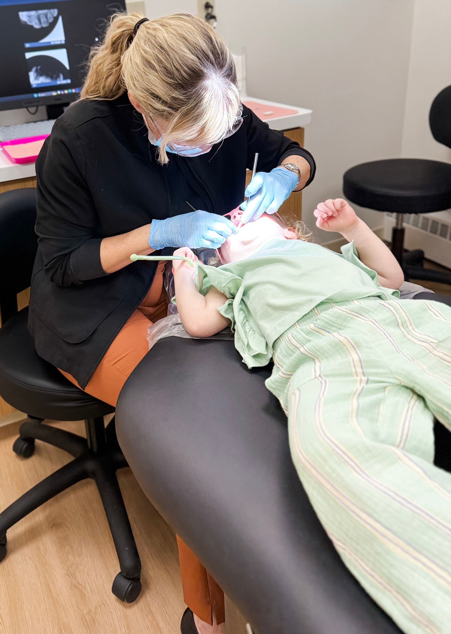 A little girl is having her throat examined by a doctor.