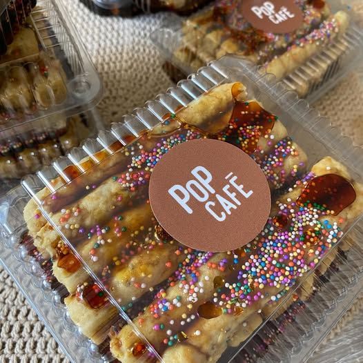 Tres personas en una mesa discutiendo muestras de diseño en una oficina moderna con paneles de madera.