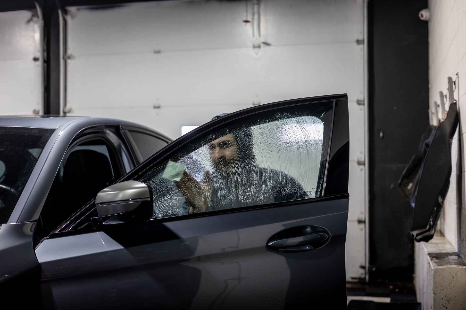 A man is sitting in a car covered in ice.