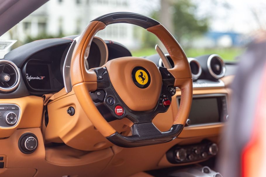 A close up of a steering wheel in a ferrari car.