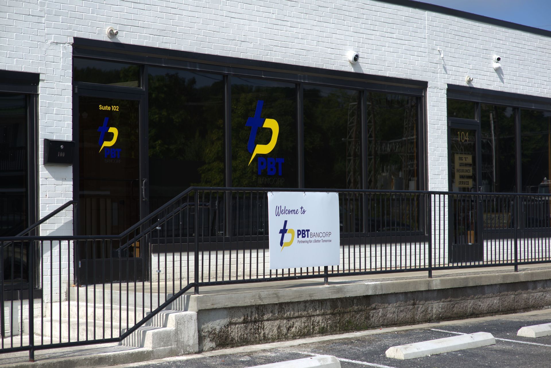 A brick building with large windows and a sign that reads 