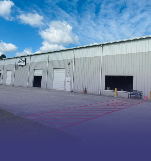B&S Body Shop building with storefront and entrance under a blue sky with clouds.