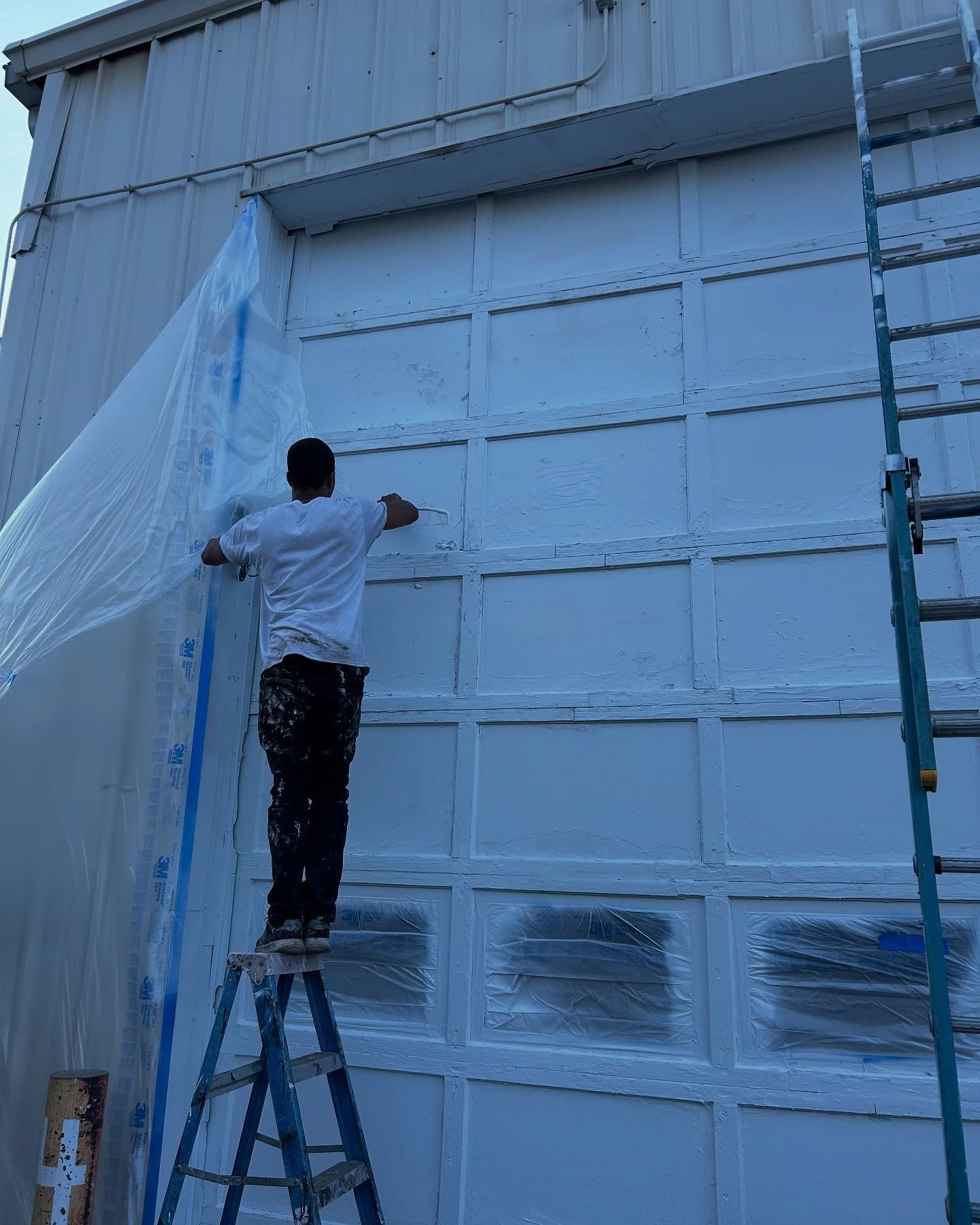 Woman in straw hat smiles, holding wine glass near a lake.